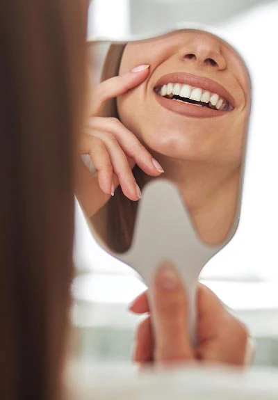 closeup of a woman smiling in the mirror