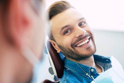 man smiling during his dental appointment at Mitten Family Dental