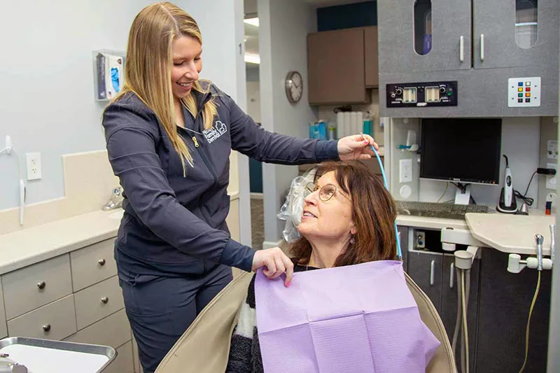 Dental assistant assisting patient with Platelet Rich Plasma treatment preparations